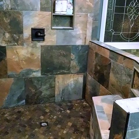 Slate tile set neatly around a stained-glass window in a bathroom wall