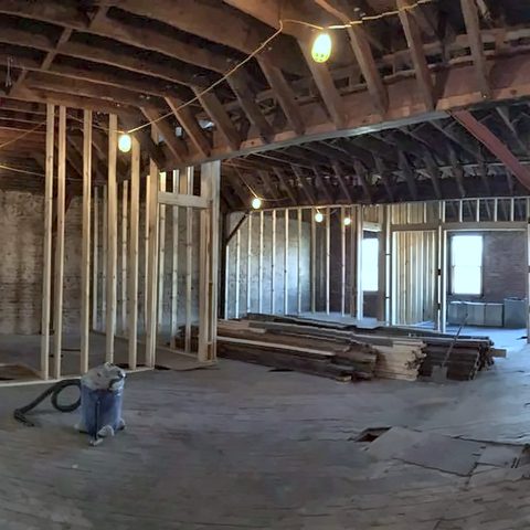A wide open commercial floor with exposed framing, joists and new stud walls