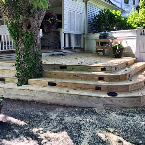 New deck steps under construction, curving around mature trees