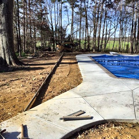 Ground excavated and prepared around a swimming pool before a new concrete deck is poured