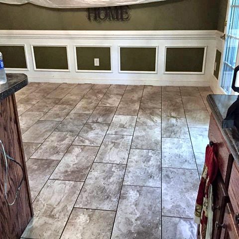 A dining area with a new ceramic tile floor and painted panelled wainscot