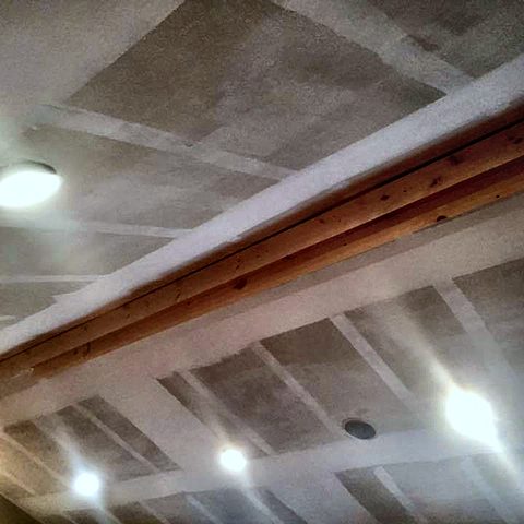 A finished vaulted ceiling with recessed lighting installed
