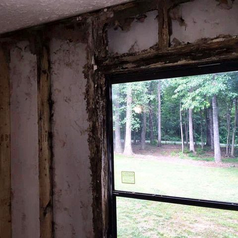 A large new window opening cut into a wall, looking out towards woodland